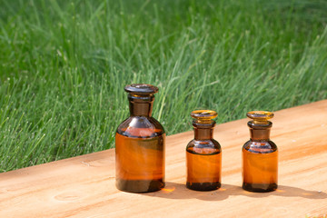 little brown bottles on booden board and grass