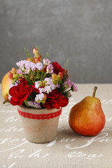 Floral arrangement with red carnations and hypericum seeds