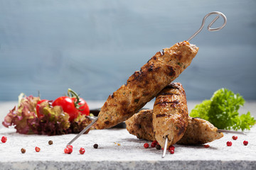Barbecued kofta - kebeb with vegetables on a plate.