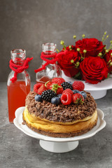 Cheesecake with chocolate topping decorated with summer fruits