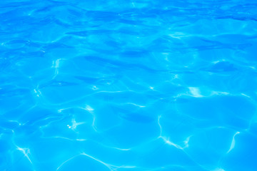 Blue pool water with sun reflections