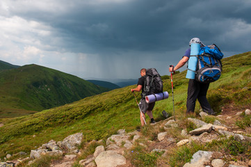 Fototapeta premium Group of tourists with large backpacks are on mountain
