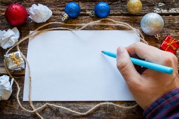 man writes a list of gifts for the new year