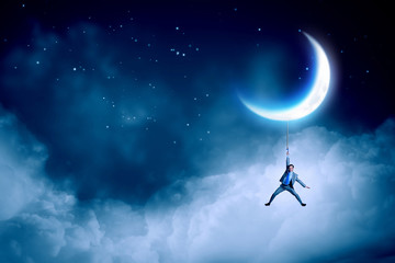 Obraz na płótnie Canvas Man hang on moon