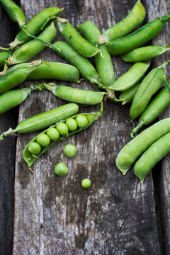 Young fresh green peas on wooden background
