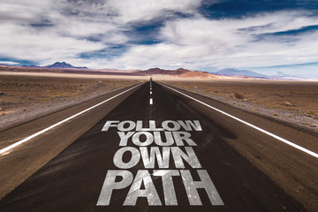 Follow Your Own Path written on desert road