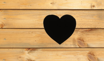 heart on the door. a hole in the shape of a heart on a wooden background