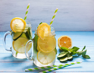Lemon and cucumber detox water in glass jars