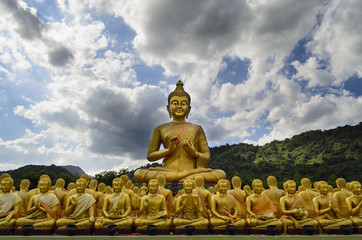 Big golden Buddha statue among many small Buddha statues