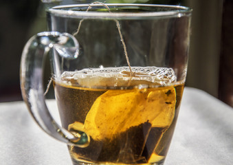 Half filled tea cup with tea bag