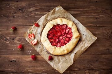 Homemade galette with strawberries on wood table