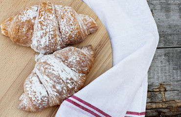 Two Croissants on the wooden table.