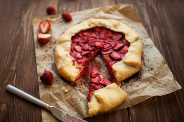Slice of strawberry galette on wood table