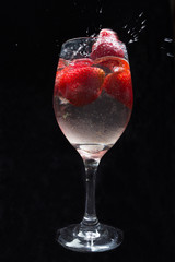 Strawberries in wine glass with water.