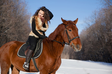 beautiful young woman and horse in winter forest