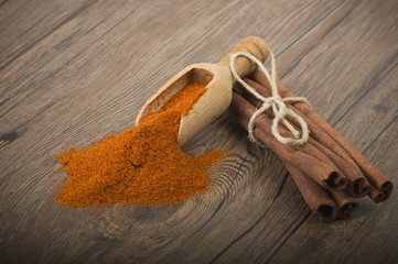 cinnamon sticks with powder on the wood table