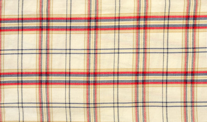 Scottish tartan pattern. Red and blue with white plaid print as background. Symmetric square pattern.