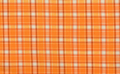 Scottish tartan pattern. Orange and white plaid print as background. Symmetric square pattern.