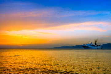 Fototapeta na wymiar sunset on Aegean sea with cruise ship