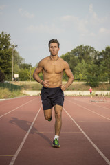 Obraz premium Runner on a track. Frontal full body shot.