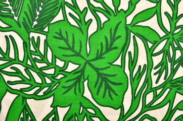 Pattern with leaves on white fabric. Green graphic flowers print as background.