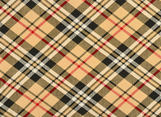 Scottish tartan pattern. Orange with red, white, black plaid print as background. Symmetric rhombus square pattern.