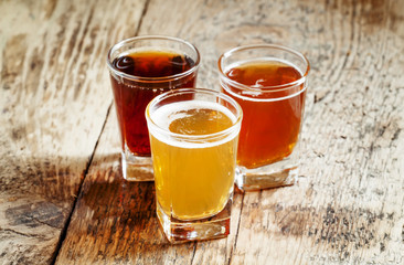 Three kinds of beer on old wooden background, selective focus