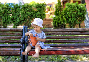 trendy little girl sitting on a wood bench with her handbag © tutye