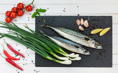 Fresh mackerel fish on a slate cutting board. Top view