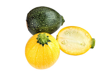Raw round yellow and green zucchini and a cut one isolated on white.