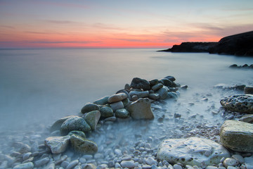 Zachód słońca nad kamienistą plażą
