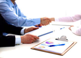 Business meeting at the table shaking hands conclusion of the