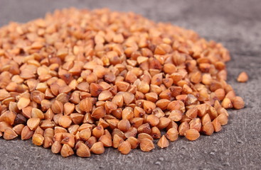 Heap of buckwheat groats on cement structure