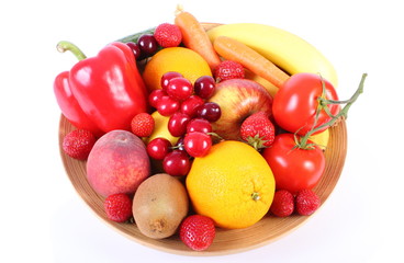 Fresh fruits and vegetables on wooden plate