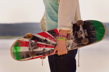 Pretty skater girl holding skateboard