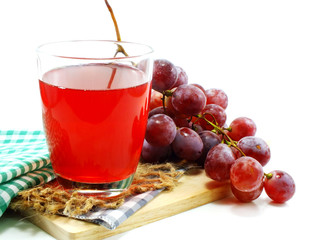 glass of red grape juice with fruit isolated on white background