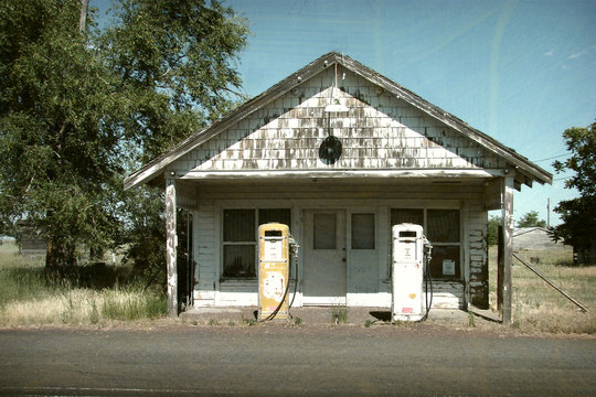 aged and worn vintage photo of old gas station and pumps