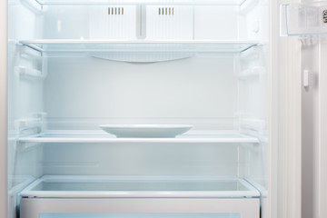Empty white plate in open empty refrigerator. Weight loss diet concept. © IntelWond