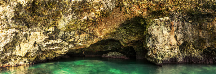 Beautiful sea cave and sun reflections on the rocks and in the water