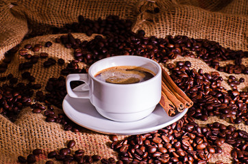 White coffee cup and coffee beans around