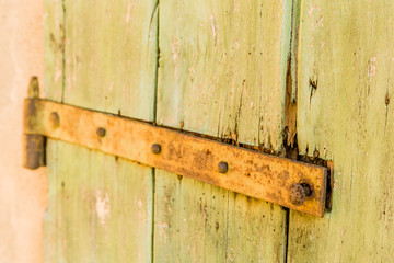 rusty hinge of an old wooden door of country barn