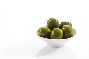 Schale mit grünen Oliven, isoliert auf weiß