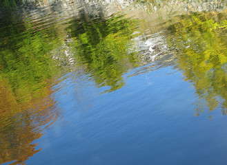 Autumn color river reflections on blue water in Stockholm, Sweden.