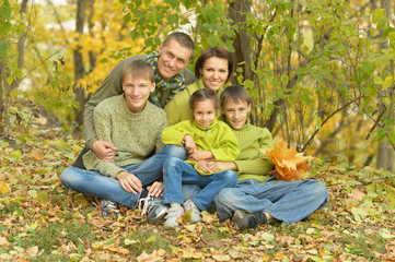 Naklejka na ściany i meble Family relaxing in autumn park