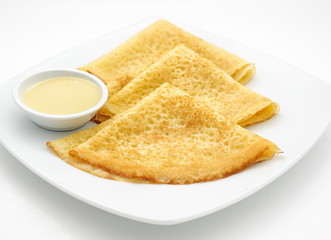 Russian pancakes with sweet milk isolated on white