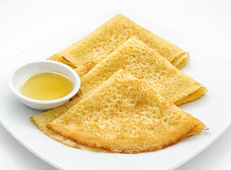 Russian pancakes with sweet milk isolated on white