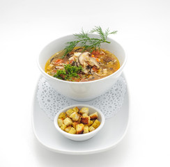 Chicken soup with pile of rusks isolated on white