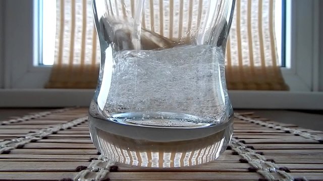 Sparkling mineral water pouring in glass