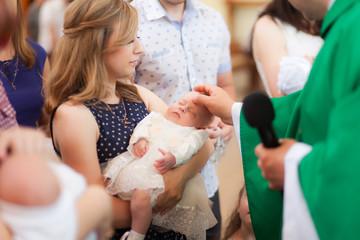Little girl on ceremony of child christening in church