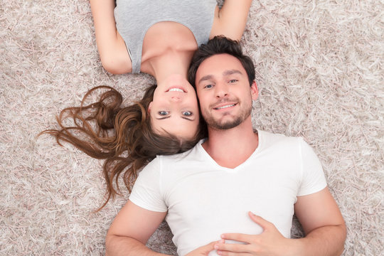 Pleasant couple lying on the carpet